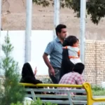 Madre con su hijo caminando de la mano por un parque, imagen de un seguro de vida familiar