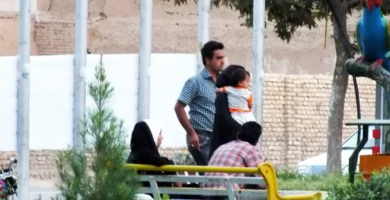 Madre con su hijo caminando de la mano por un parque, imagen de un seguro de vida familiar