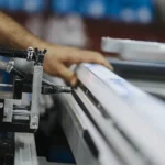 Trabajador operando maquinaria en un puesto de fábrica, imagen de accidentes laborales en convenio