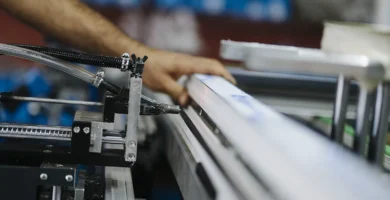 Trabajador operando maquinaria en un puesto de fábrica, imagen de accidentes laborales en convenio