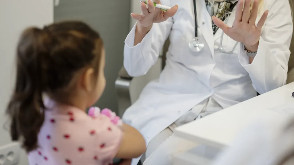 Pediatra revisando a un niño en consulta, imagen ilustrativa del seguro de salud para niños