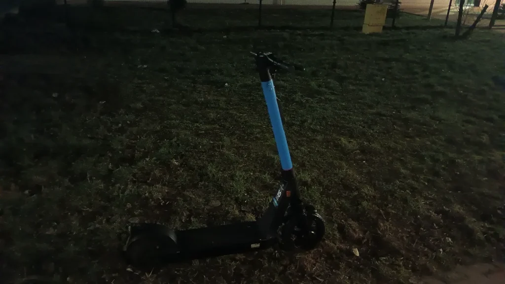 Patinete eléctrico compartido aparcado junto a una acera