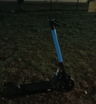 Patinete eléctrico compartido aparcado junto a una acera