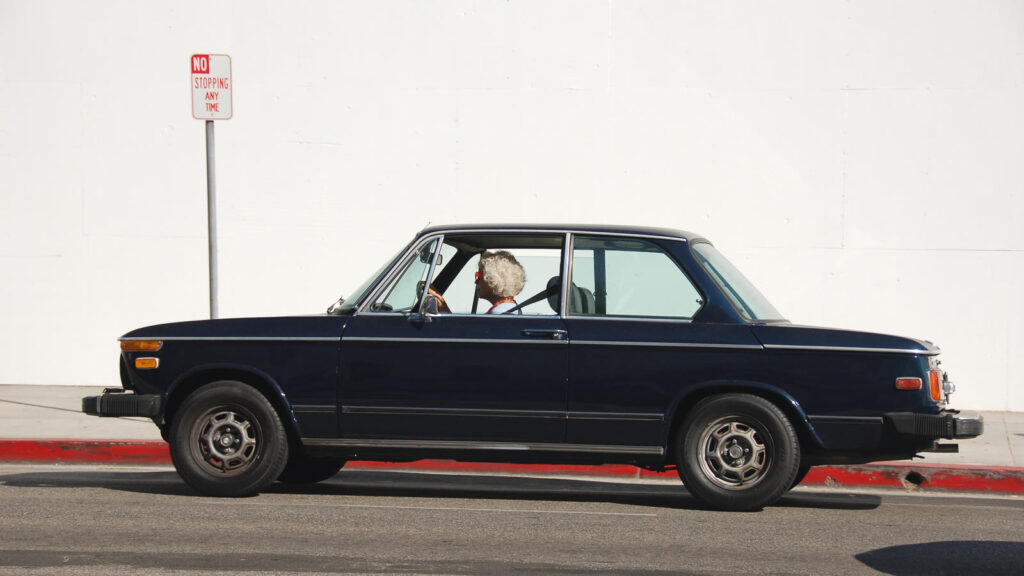 Mujer mayor conduciendo su coche azul