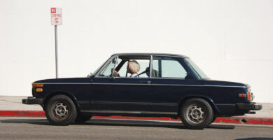 Mujer mayor conduciendo su coche azul