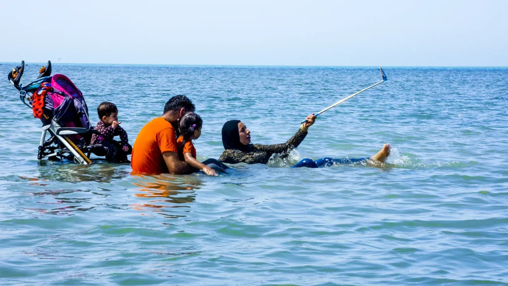 Familia feliz bañándose en el mar (foto de archivo)