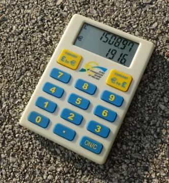 Calculadora de moneda sobre documentos, foto de archivo (índice de precios de seguros 2026)