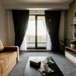 Salón de una vivienda con sofá, mesa de centro y ventanales