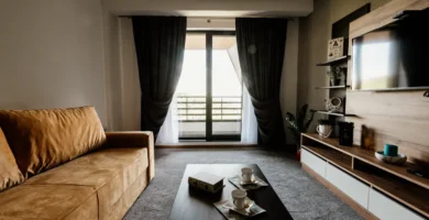 Salón de una vivienda con sofá, mesa de centro y ventanales