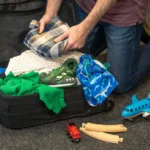 Padre preparando la mochila de su hijo antes de un viaje familiar