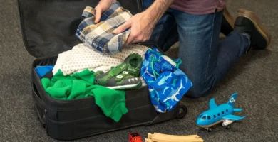 Padre preparando la mochila de su hijo antes de un viaje familiar