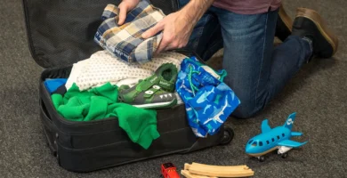 Padre preparando la mochila de su hijo antes de un viaje familiar
