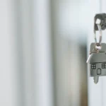 Llaves de casa con llavero junto a una puerta