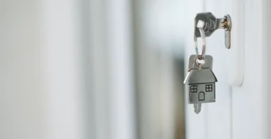 Llaves de casa con llavero junto a una puerta
