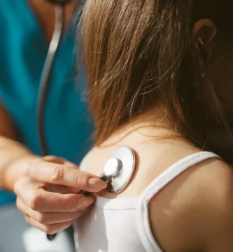 Médica ausculta a una paciente con un estetoscopio
