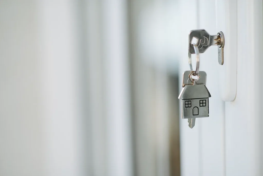 Llaves de casa con llavero junto a una puerta
