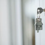 Llaves de casa con llavero junto a una puerta